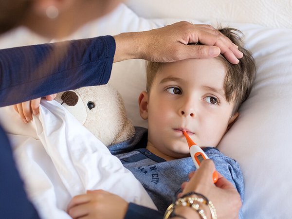Mutter versorgt Kind mit Fieber